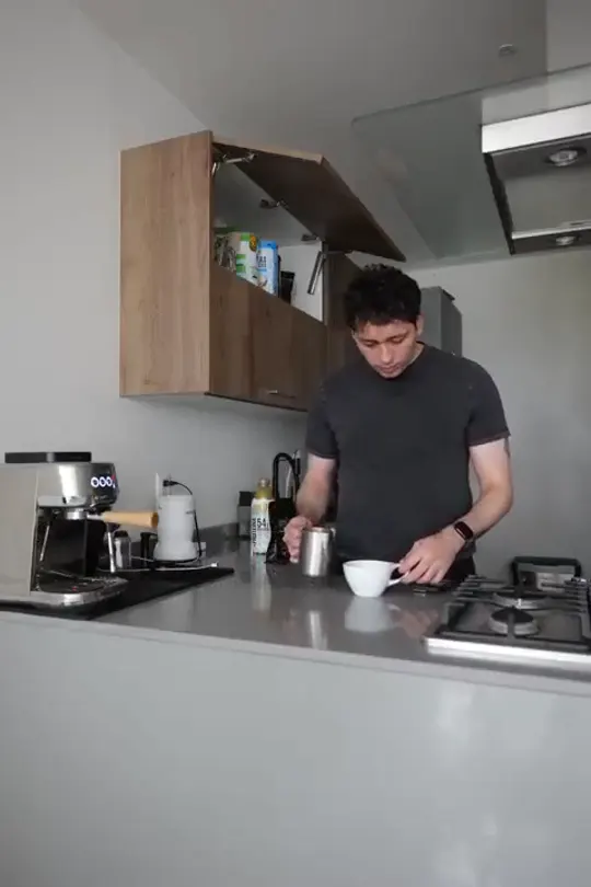 A still from Isaac's own kitchen footage: reaching for a coffee cup on the counter